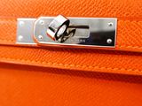 an orange leather suitcase with a metal lock on the handle