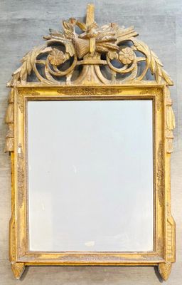 un miroir accroché au mur, avec un cadre doré