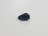 a tear shaped blue sapphire stone on a white surface