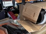 a pile of boxes and a box of clothes on top of a shelf