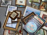a lot of framed pictures on the floor of this room