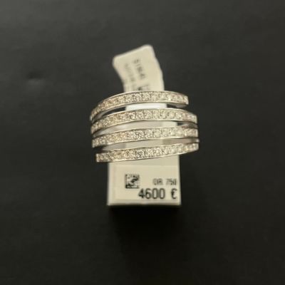 a close up of a silver ring with diamonds on a black surface