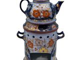 a blue and white teapot with a flower design on it