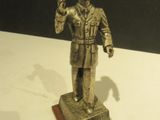 une statue en bronze représentant un homme coiffé d'un haut-de-forme et vêtu d'un uniforme