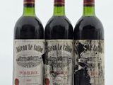 trois bouteilles de vin rouge posées sur une table blanche