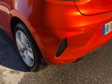 a close up of a red car parked in a parking lot