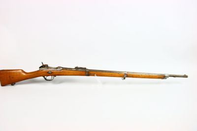 un vieux fusil sur une surface blanche avec un fond blanc