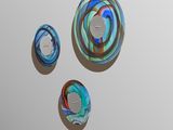 trois œuvres d'art posées sur une surface blanche