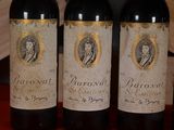 three bottles of red wine are lined up on a table