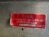 a red sticker on the back of a silver vehicle
