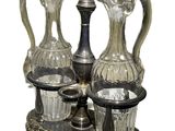 three glass vases and a silver plate on a stand