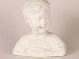 a white statue of a young boy with a smile on his face