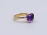 a close up of a gold ring with a heart shaped amethorate