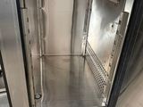 a stainless steel oven with a door open on a tiled floor