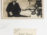an old photo of a man in a suit sitting at a desk