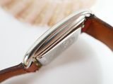 a close up of a watch with a shell in the background