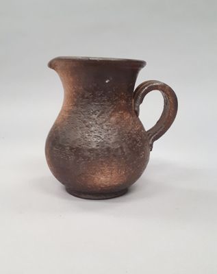 an image of a brown vase with a handle on a white surface
