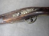 an old gun with a wooden handle on a gray surface