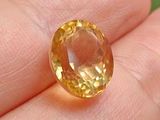 an image of a close up of a person ' s hand holding a yellow sapphire