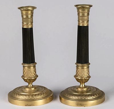 une paire de bougeoirs noirs et dorés sur fond blanc
