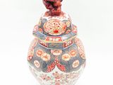 a vase with a bird on top of it on a white surface