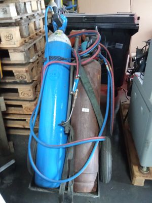 un extincteur bleu posé à côté d'une pile de palettes