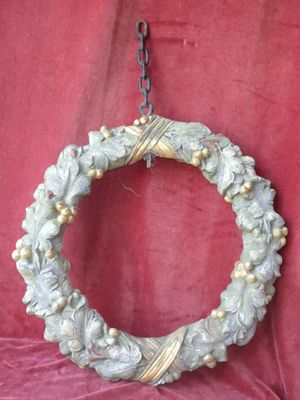 a wreath hanging on a chain on a red cloth