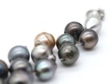 a row of different colored pearls on a white surface