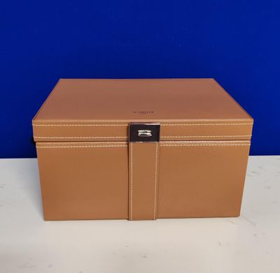 a tan leather box with a lock on top of it