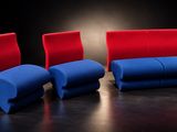 trois chaises rouges et bleues posées sur une surface noire