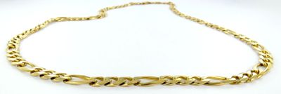 gros plan d'un collier à chaîne en or sur une surface blanche