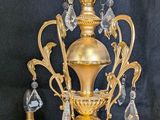 a gold colored chandelier with a crystal chandelier hanging from it