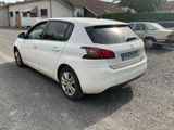 a small white car parked in front of a house