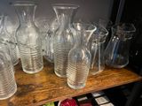 a lot of glass vases on a shelf next to strawberries