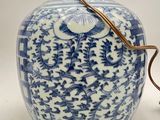 a blue and white vase with a handle on a table