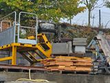 a large pile of wood sitting on top of a cement wall