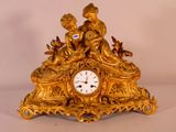 une horloge en or surmontée d'une statue