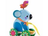 koala en bois monté sur une petite voiture jouet surmontée d'une fleur