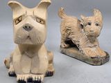 une paire de figurines de chiens en céramique, dont l'une est assise par terre