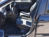 the interior of a car with the door open and the driver ' s seat down