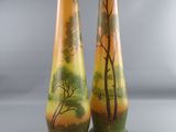 two vases with trees painted on them sitting side by side