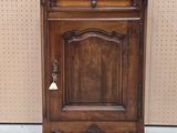une image représentant une armoire en bois surmontée d'une cloche