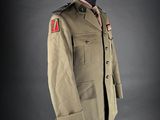 an army uniform on a mannequin stand against a black background