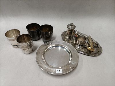 silver plate and silver cups and saucers on a white surface