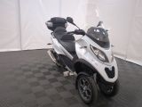 a white and black scooter parked on a black and white checkered floor