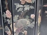 a black room divider with flowers and birds painted on it