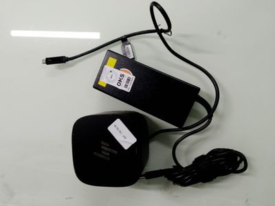 un bloc d'alimentation noir et un chargeur posés sur une table blanche