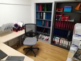a desk with a chair and a laptop on it