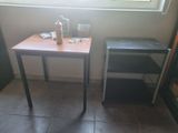 a small table with a bottle on it next to a window