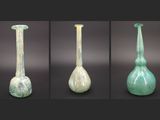 quatre vues différentes d'un vase en verre vert à base blanche